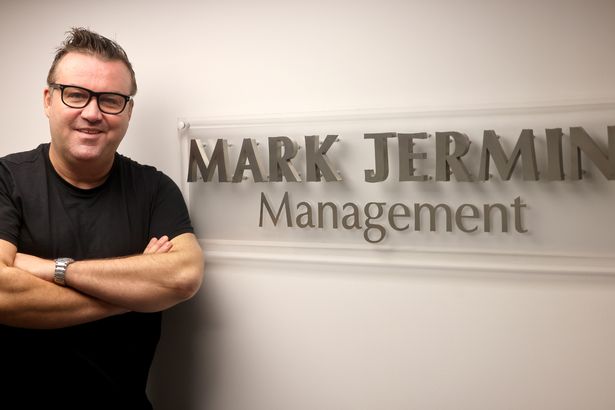 Mark Jermin, standing alongside a Mark Jermin management sign