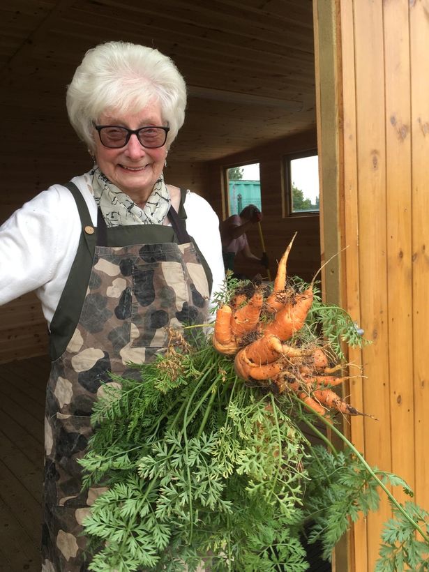 Mary Roberts, 90, with her carrots grown at the Wonky Garden