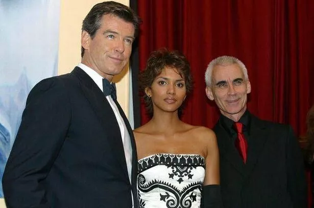 Pierce Brosnan. Halle Berry and Lee Tamahori pose in front of a red curtain
