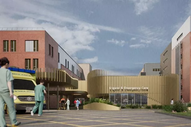 A concept design showing the outside of a hospital with a new urgent treatment centre, with an ambulance to the left of the image