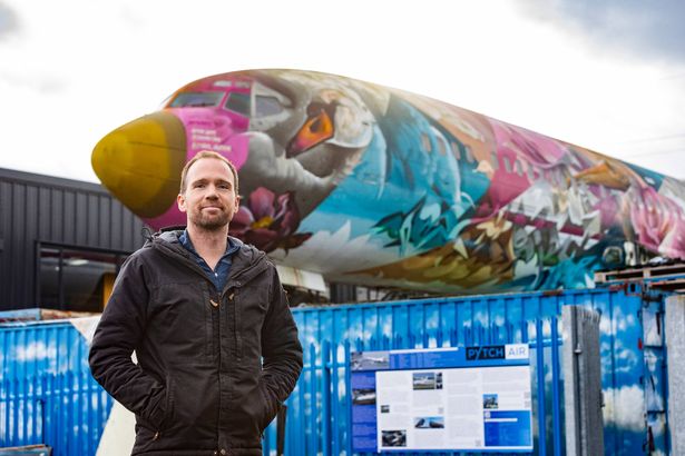 A man in front of a painted plane