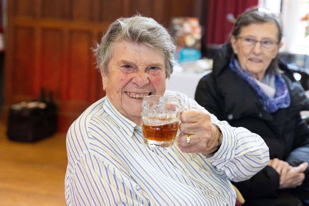 A person holding a glass of beer
