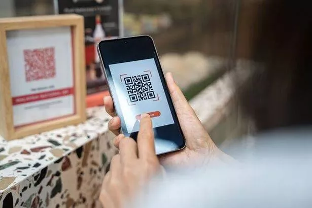 Scanning QR code for mobile payment at cafe counter