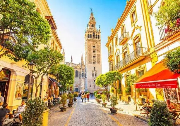 Seville, Spain - 6 March 2020: Sunny Seville street and scenic view of Giralda tower