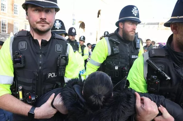 Police arrest protesters on College Green in Bristol on Saturday, November 29, 2025, for writing placards saying: 'I oppose genocide - I support Palestine Action'