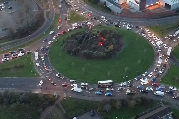 An aerial photo showing heavy traffic in and around Spitfire Island by Castle Vale after a five-vehicle crash on Chester Road towards the M6, with a police car blocking the road 