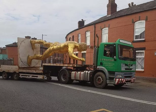The golden nude statue on the back of a truck