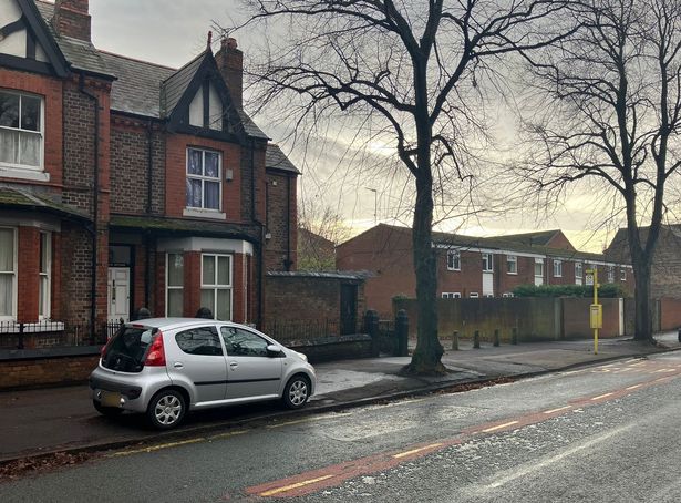 A car parked on a pavement by a bus stop on Rose Lane. 