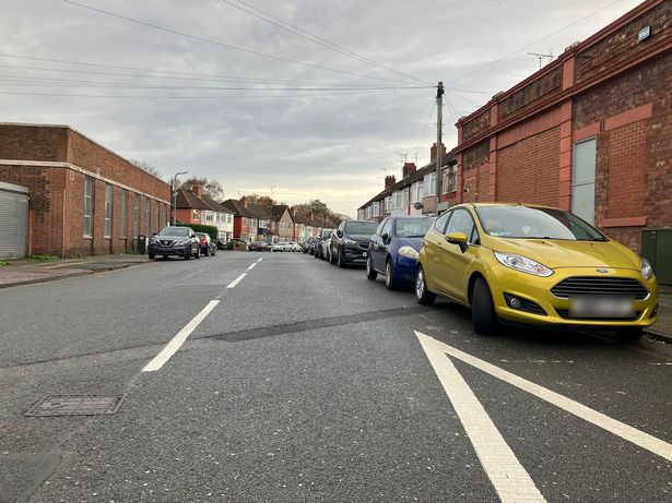 Cars parked on Pitville Avenue at the junction with Rose Lane. 