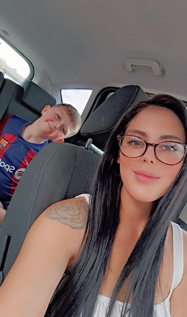 A woman with long dark hair with her son