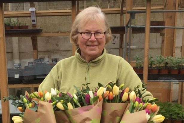 Jean Beesley, 78, with flower bouquets made by volunteers at the Wonky Garden