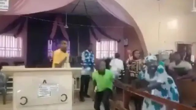 People inside a church reacting to the sound of gunfire