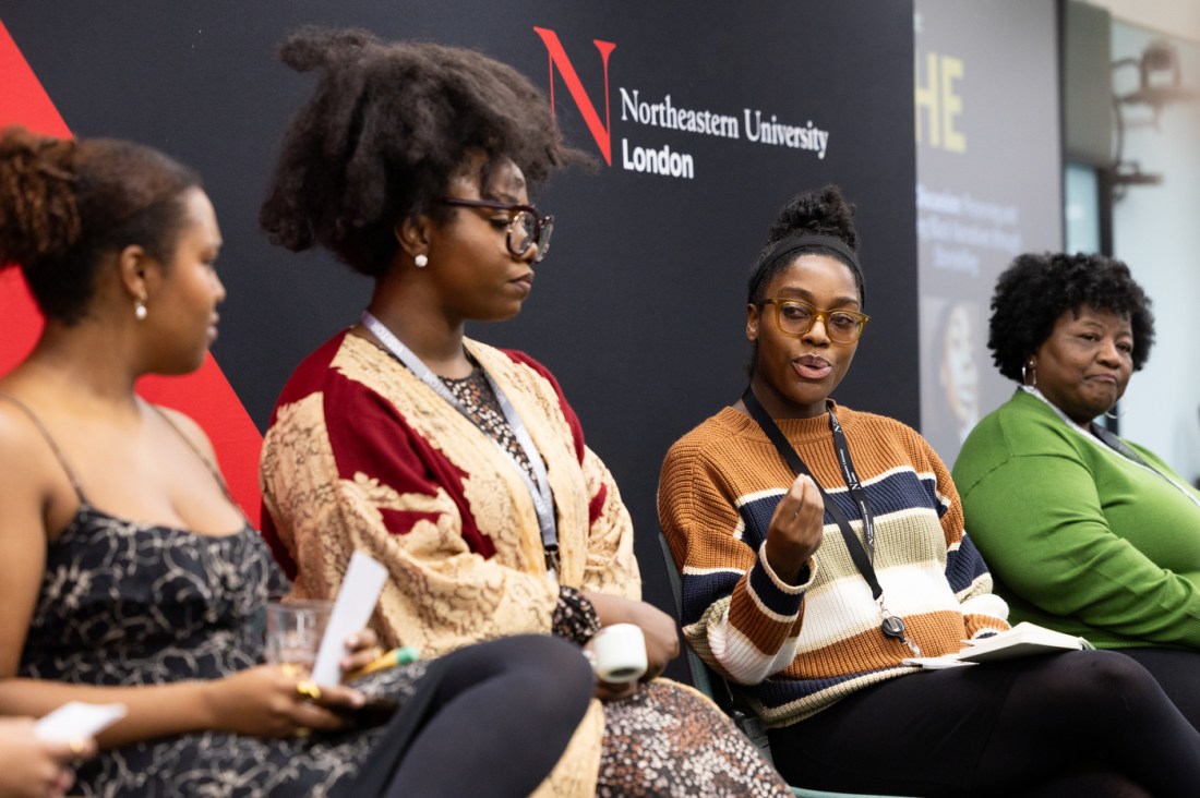 Four panelists seated on stage during the “Night at the Museum” event at Northeastern University London, engaged in discussion.