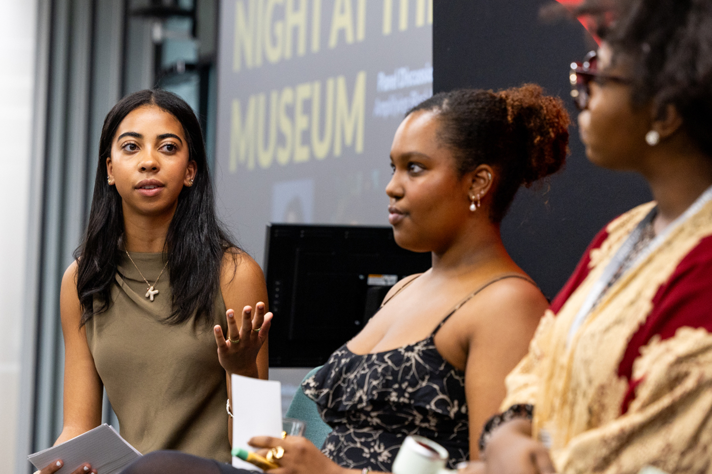 One female student turned and gesturing to two others on stage during the Night at the Museum event.