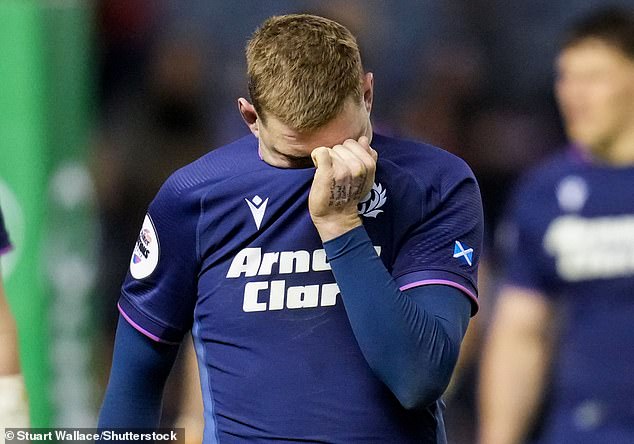 Finn Russell buries his face in his shirt after a game in which Scotland threw away a 21-0 lead