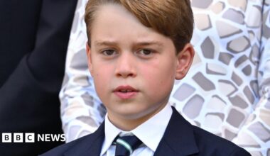 Two housemates stand in their kitchen, smiling at the camera