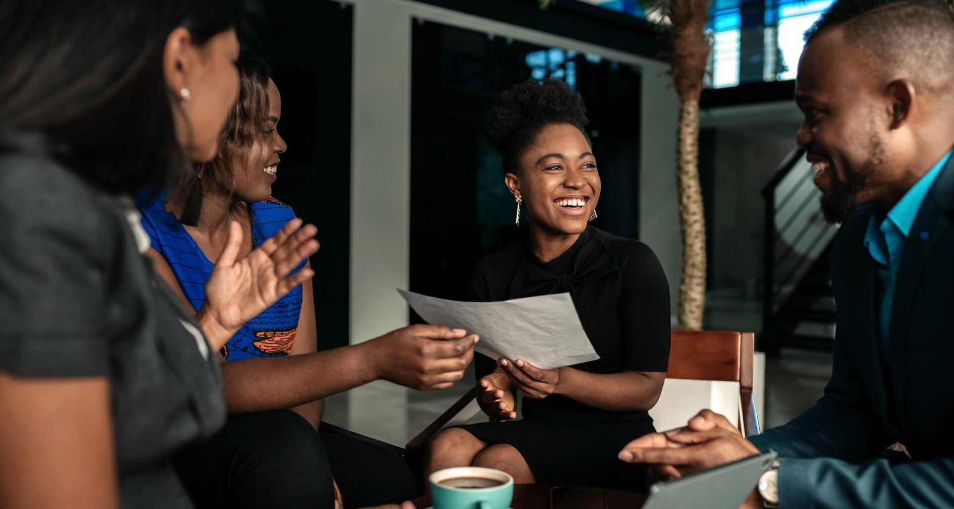 A group of young professionals meeting up and chatting, smiling.