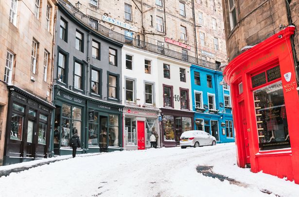 Edinburgh, Scotland - A view up Victoria Street in Edinburgh's Old Town with a few pedestrians on the pavement passing the street's shops and restaurants.