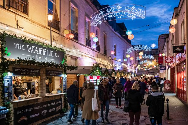 People strolling at the Christmas market set up in the old town of Bath.