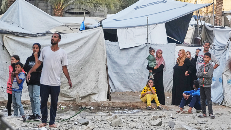 Palestinians in Deir al Balah examine the aftermath of an airstrike. Pic: AP