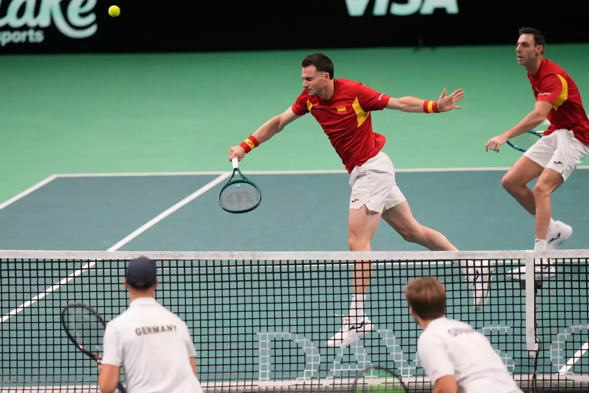 Spain's Pedro Martinez, top left, returns the ball with his teammate Marcel Granollers during a Davis Cup double semifinal tennis match against Germany's Kevin Krawietz and Tim Puetz, in Bologna, Italy, Saturday, Nov. 22, 2025. (AP Photo/Luca Bruno)