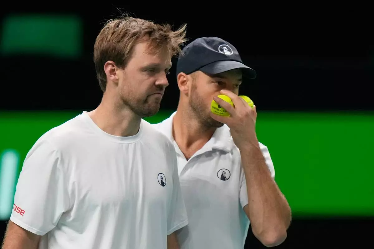 Germany's Kevin Krawietz, left, and Tim Puetz talk during a Davis Cup double semifinal tennis match against Spain's Marcel Granollers and Pedro Martinez, in Bologna, Italy, Saturday, Nov. 22, 2025. (AP Photo/Luca Bruno)