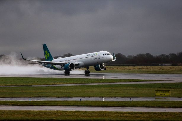An Aer Lingus flight kicks up spray as it lands at Manchester Airport on Friday afternoon.