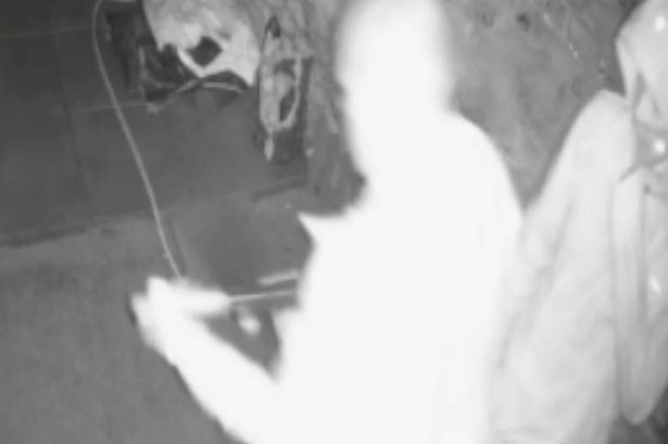 A CCTV still of Charles Byers attaching a silencer to a firearm