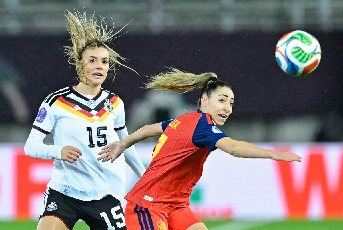 Germany's Selina Cerci, left, and Spain's Olga Carmona fight for the ball during the women's nations league soccer match between Germany and Spain in Kaiserslautern, Germany, Friday Nov. 28, 2025. (Uwe Anspach/dpa via AP)