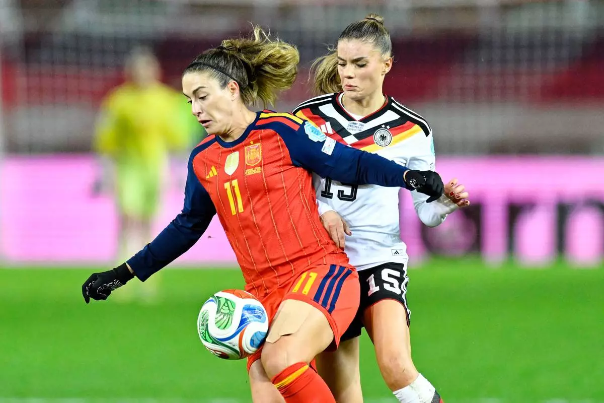 Germany's Selina Cerci and Spain's Alexia Putellas, left, fight for the ball during the women's nations league soccer match between Germany and Spain in Kaiserslautern, Germany, Friday Nov. 28, 2025. (Uwe Anspach/dpa via AP)