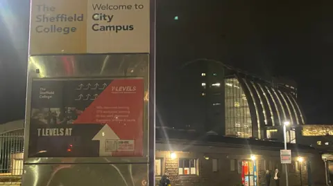 Simon Thake/BBC Exterior shot of The Sheffield College, with signs saying City Campus, and stone, glass and steel buildings behind.