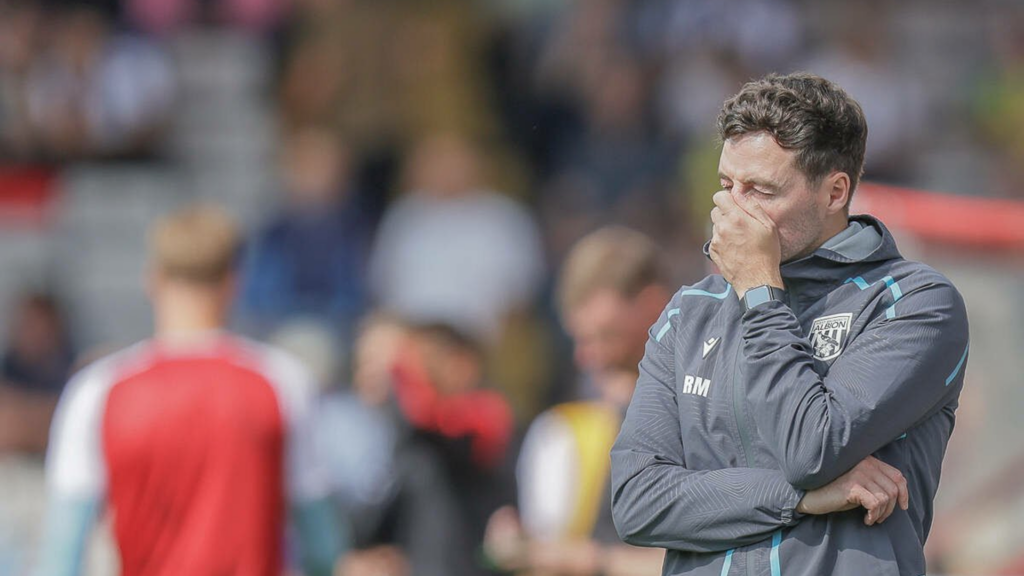 West Brom manager Ryan Mason stands with his hand over his face.