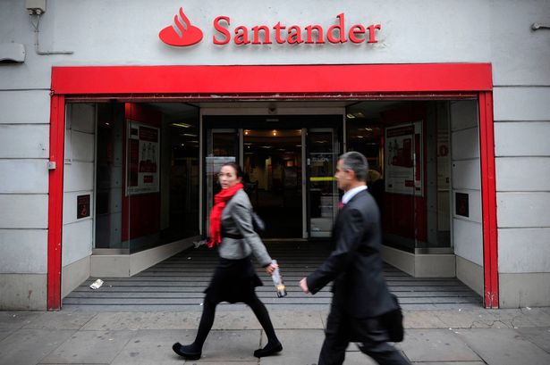 People walk past a branch of Santander in central London, on October 7, 2011. 