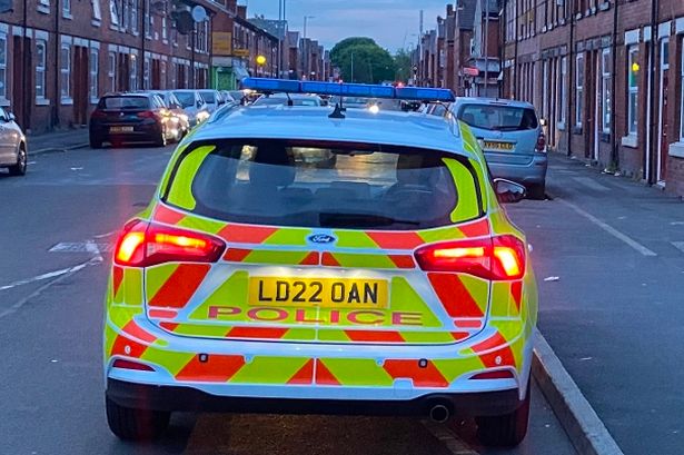 Stock image of a police car on Lloyd Street South in Moss Side