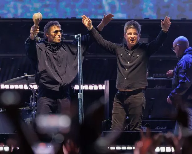 Liam and Noel perform onstage at the Oasis Live '25 World Tour