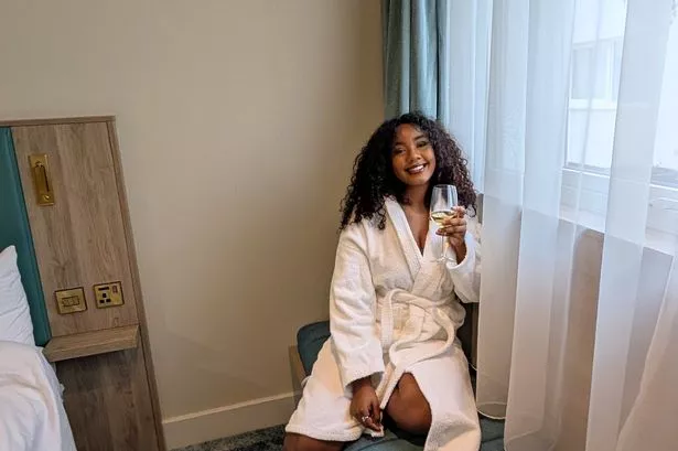 Shania sitting in a robe with wine 