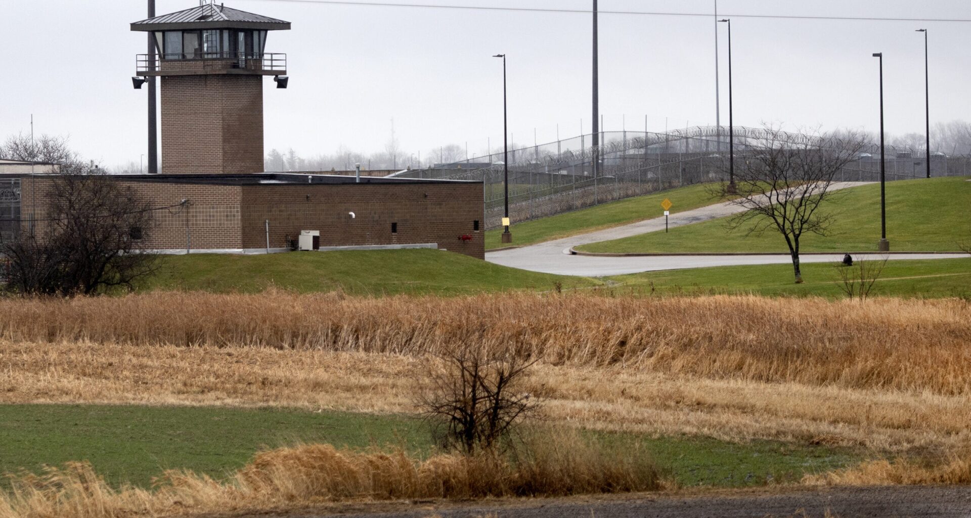 An observation tower and fence can be seen across from a field