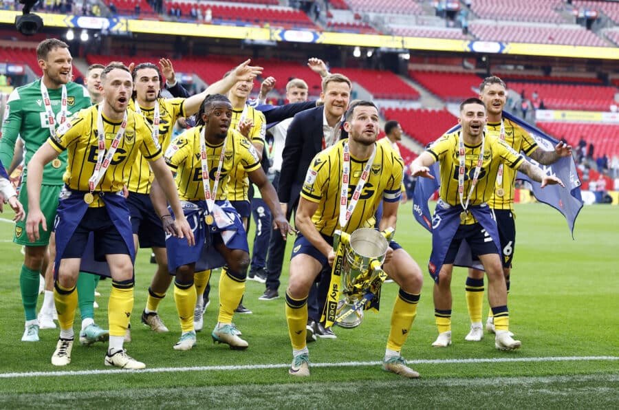 Oxford United's Elliott Moore celebrates with the trophy and teammates after winning the League One play off final