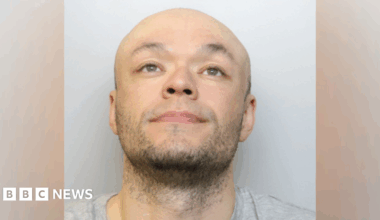 Jamie Doyle custody image. He is wearing a grey T-shirt and is looking up into the air.