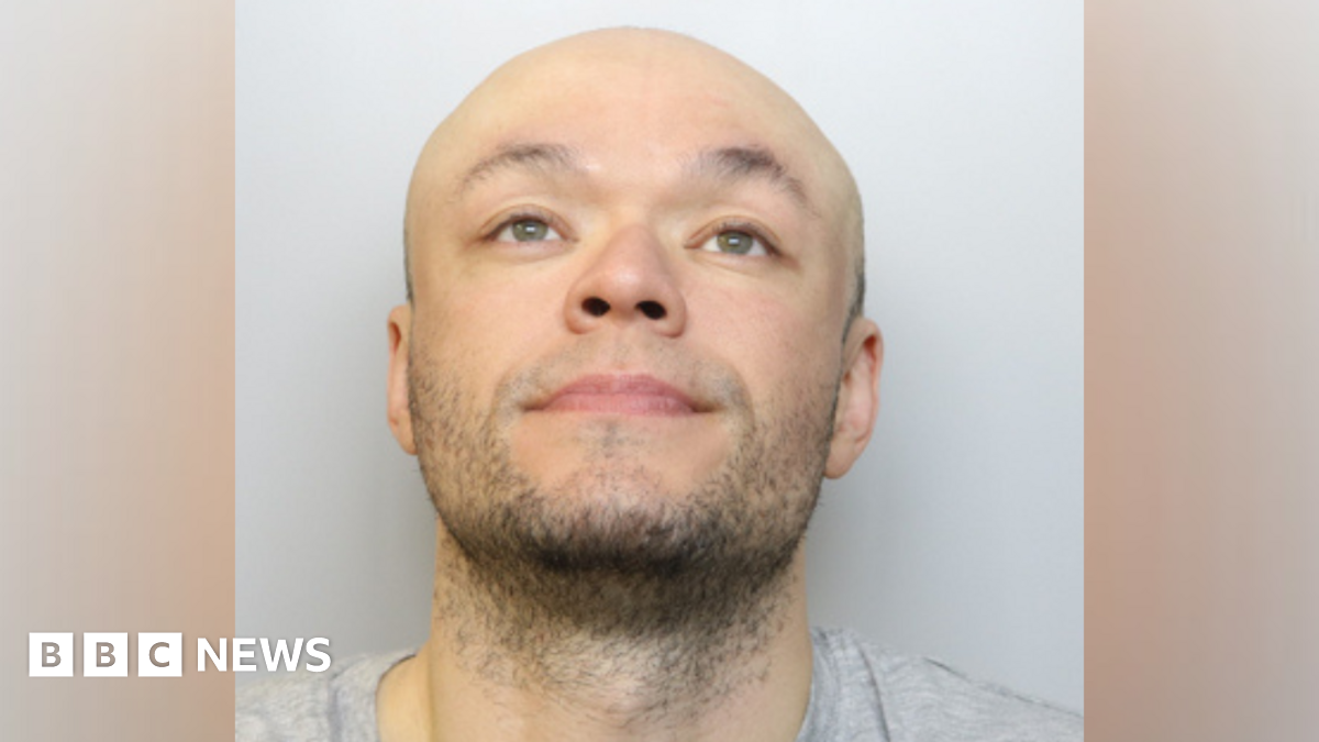 Jamie Doyle custody image. He is wearing a grey T-shirt and is looking up into the air.