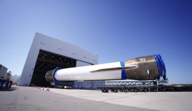 a large white rocket is rolled into a hangar horizontally