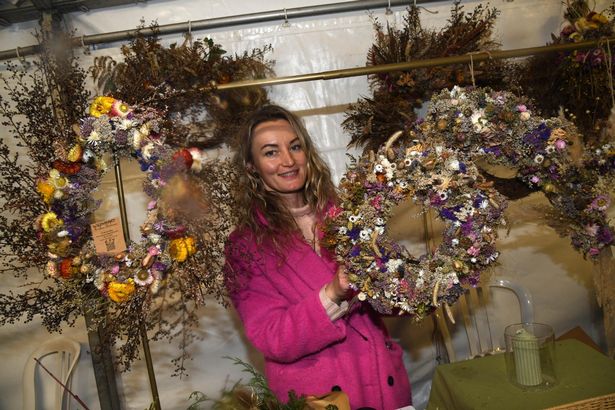 A woman holds a wreath
