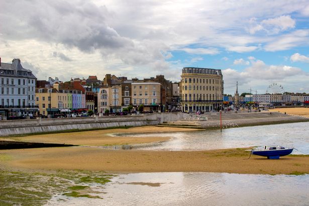View of Margate bay, sandy beach at low tide, King's Steps, and buildings on The Parade in Margate, Kent, Great Britain.