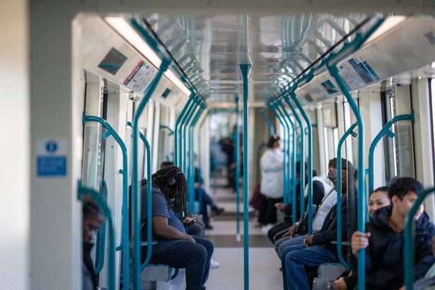 Passengers sat on one of the new DLR trains with walk-through carriages