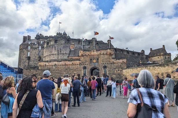 Edinburgh, UK - July 18 2025: Tourists queueing at the entrance of the iconic Edinburgh Castle, a historic fortress and major visitor attraction under a blue sky with clouds in the summer