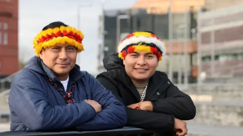 Size of Wales Teófilo Kukush Pati, President of the Wampís Nation - an indigenous nation from the Peruvian Amazon – and Tsanim Wajai Asamat standing outside the Senedd in Cardiff Bay