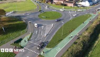 An aerial shot of a roundabout with green segregated cycle lanes going around the edge.