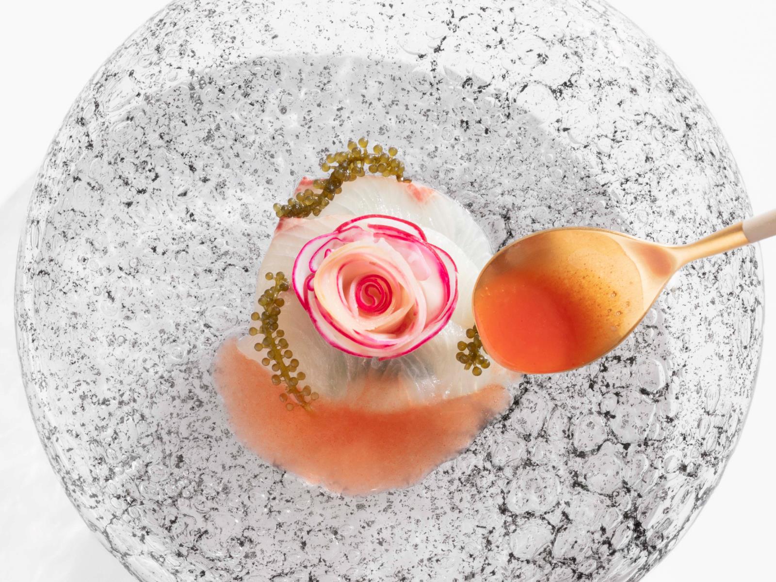   Cured hamachi, spinach and watercress salad, a flower made of paraguayan peach and spicy radishes, along with other ingredients, make up this elegant dish at EMi, a restaurant in Madrid that now holds One Star. © Francis Rosso/Emi