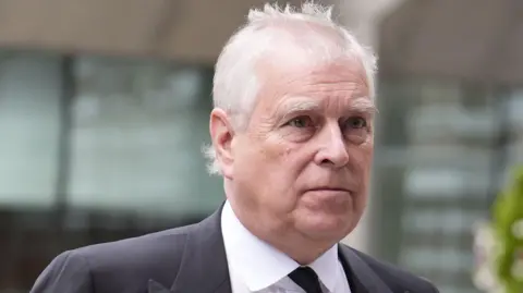 PA Media Andrew Mountbatten Windsor has grey hair. He is looking to the right. You can see the top of a suit and black tie.