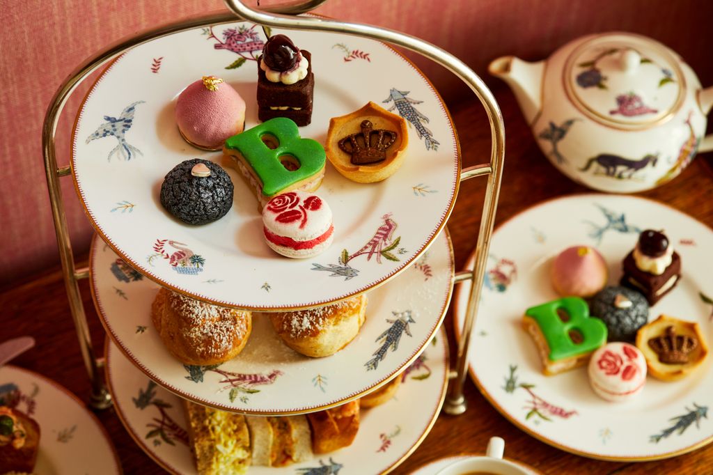 tiered cake plate with scones, sandwhiches and cakes on